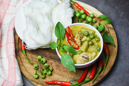 亚洲餐桌上的食品泰国汤碗上的食物绿咖喱鸡以及配有蔬菜成份的番茄米面背景图片