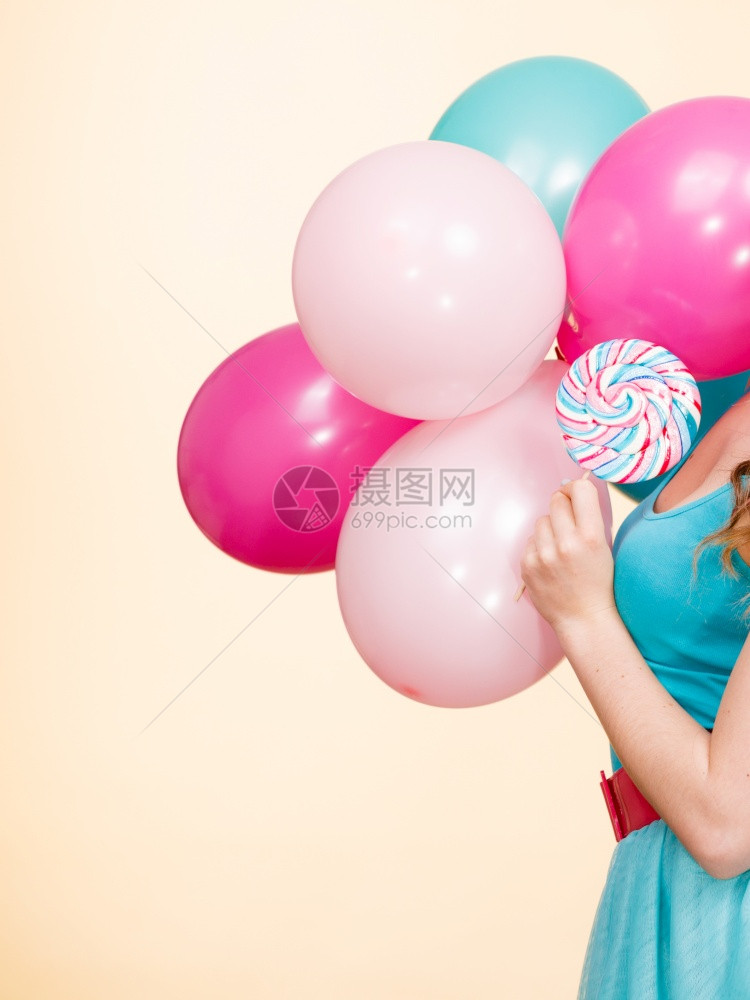 夏假庆典和幸福概念工作室拍到了明亮的黄色女人拿着彩色的气球和棒糖图片