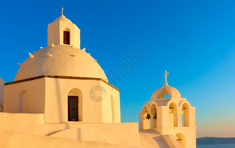 希腊圣托里尼岛日落之光的希腊教堂图片