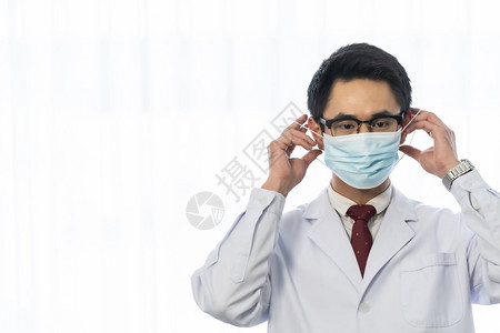 身戴保护面罩的亚洲男医生肖像图片