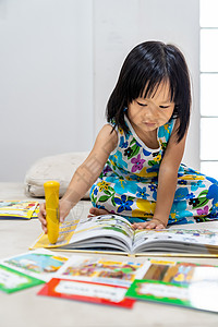 书舍名苑亚洲女童在家里客厅阅读互动式书作为家庭学校教育而城市则因为全世界可食19种流行病而被封锁家舍林为学龄前概念做准备背景