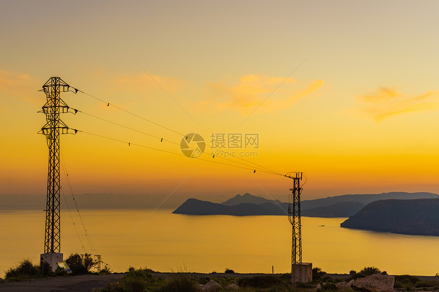日落时带输电塔的海岸线高压电塔MesaRoldanCabodeGata西班牙图片