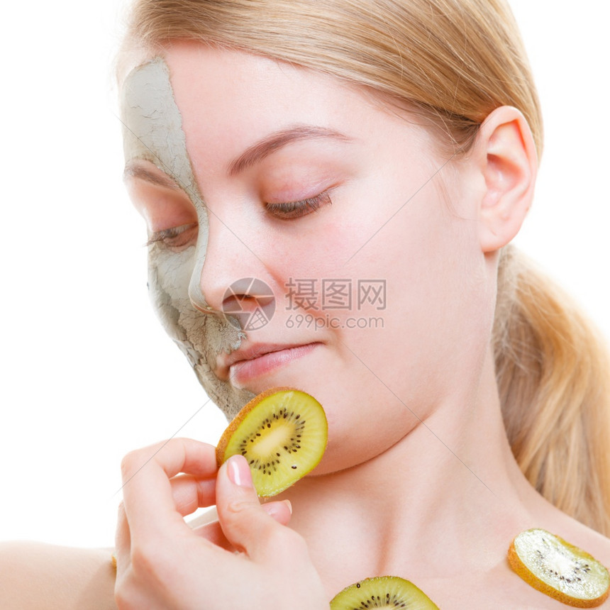 年轻女子脸上戴着泥绿色藻类面罩的女士拿着小木薯片图片