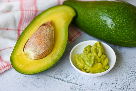 Avocado切片半和avocado浸在桌子背景水果健康食品概念上图片