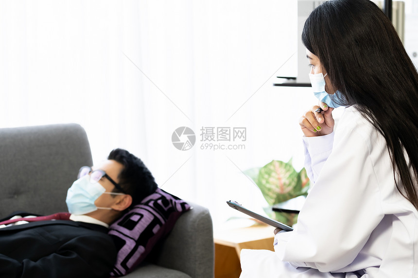 精神病医师女生病人之家与抑郁的亚洲商人一起工作他们躺在沙发扶手椅上在客厅里图片