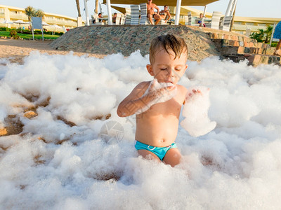 在海边迪斯科派对上小孩男的有趣照片在沙滩迪斯科派对上被肥皂乐覆盖在中图片