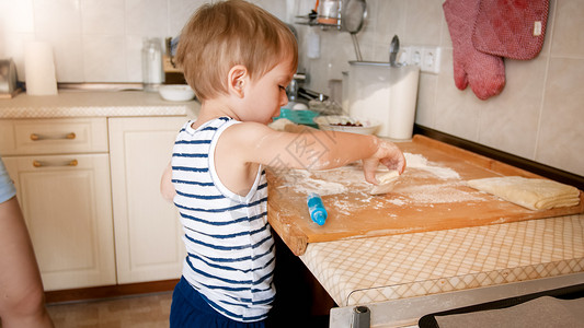 可爱的3岁男孩烤饼干和卷的近亲肖像小厨师图片