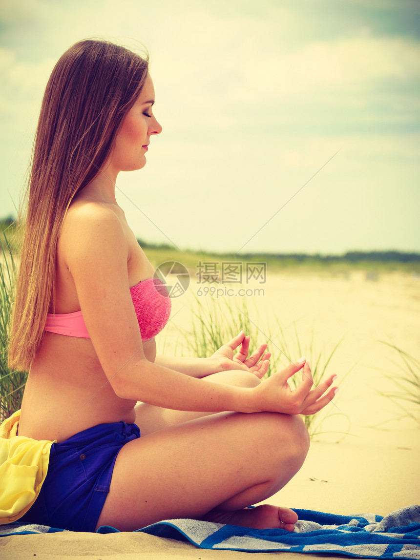 放松时间年轻女孩在瑜伽练习上闲暇时间放松身体和精神夏天在海滩上休息女人在沙滩上做瑜伽图片