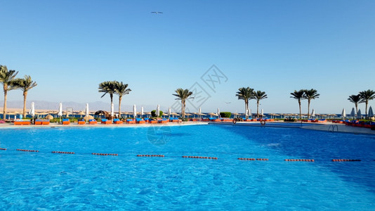夏季酒店沙滩度假胜地与蓝天对面的美丽户外游泳池照片图片