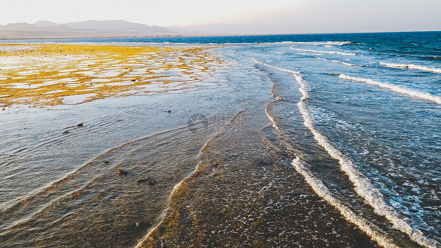 海浪在日落光下滚动和摇在死珊瑚礁和岩石上海浪在日落光下滚动和摇在死珊瑚礁和岩石上图片