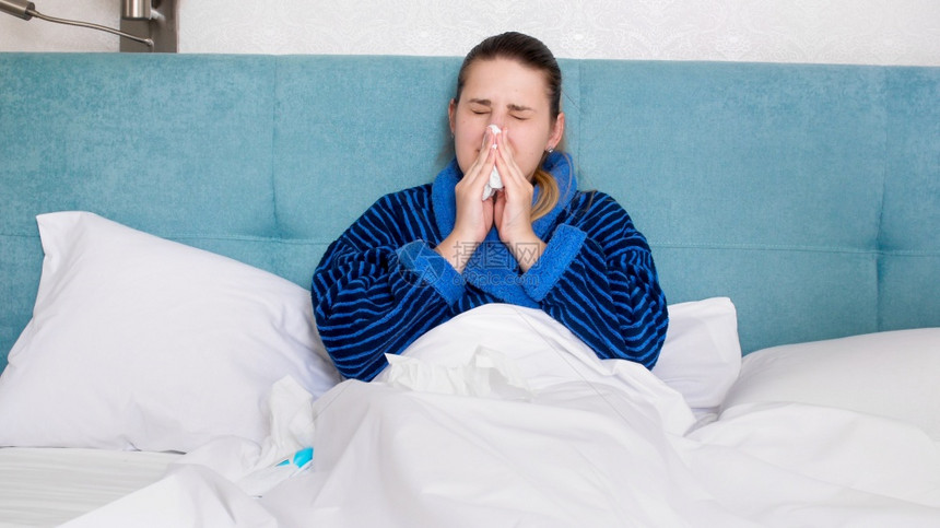 患有流感在纸组织中流鼻涕在纸组织中流鼻涕在纸组织中流鼻涕的患病妇女图片