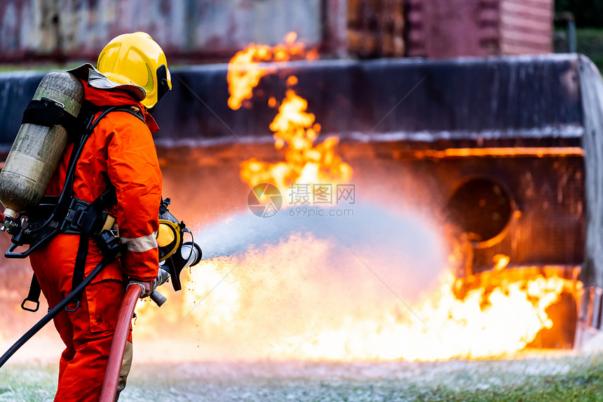消防员使用化学泡沫灭火器与油轮卡车事故的火灾作斗争消防员安全事故和公共服务概念图片