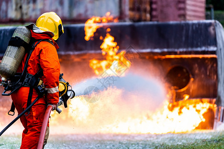 火的使用素材消防员使用化学泡沫灭火器与油轮卡车事故的火灾作斗争消防员安全事故和公共服务概念背景