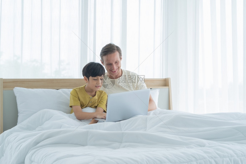 和父亲在床上用笔记本电脑图片