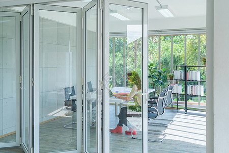 办公室门素材商业妇女高加索人使用笔记本电脑在办公室会议工作用玻璃门在房间里工作背景