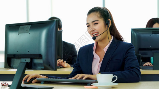 身着头盔的商界人士在办公室工作为远程客户或同事提供支助呼叫中心电话推销客户支助代理提供电话视频会议服务女商人高清图片素材