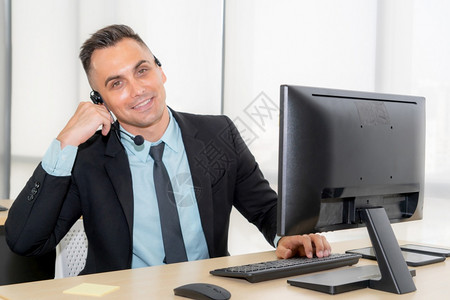 身着头盔的商界人士在办公室工作为远程客户或同事提供支助呼叫中心电话推销客户支助代理提供电话视频会议服务桌面高清图片素材