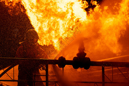火焰爆炸消防员使用水雾式灭火器与石油管道泄漏和钻机天然气站爆炸产生的火焰作斗争消防员和工业安全概念背景