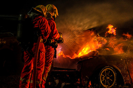 消防员使用Twirl水雾灭火器与高速公路交通碰撞事故的汽车火焰作斗争消防员安全事故和公共服务概念背景图片