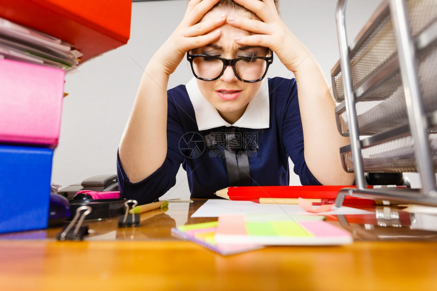 工作时的争吵不良工作关系概念令人沮丧的女商悲伤和疲劳坐在办公桌里装有夹子的文件上工作图片