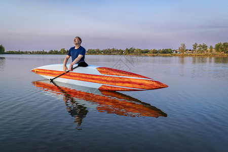 高级男起身在科罗拉多州一个平静的湖上享受日出清晨娱乐和健身概念图片