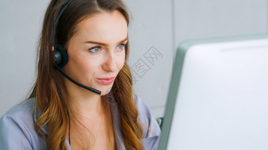 身着头盔的商界人士在办公室工作为远程客户或同事提供支助呼叫中心电话推销客户支助代理提供电话视频会议服务女性的高清图片素材