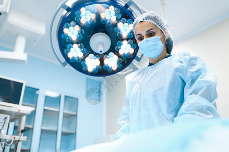 手术室背景灯外科手术穿制服的医生疗诊所工作人员医药和保健院的手术室穿礼服和戴面罩的女外科医生帽子高清图片素材