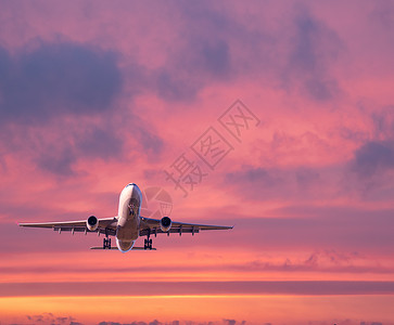 飞机在夏季日落时正飞往云层上空航空高清图片素材