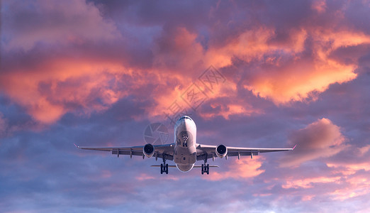 飞机在夏季日落时正飞往云层上空飞行高清图片素材