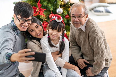 多代的亚裔家庭妈女儿和祖父在装饰圣诞品后图片