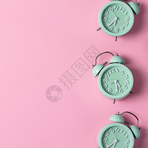 绿色闹钟和的创意布局以粉色糊面背景最小概念平坦模式图片