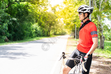 穿着运动服骑自行车运动员在农村公路上停下休息图片素材