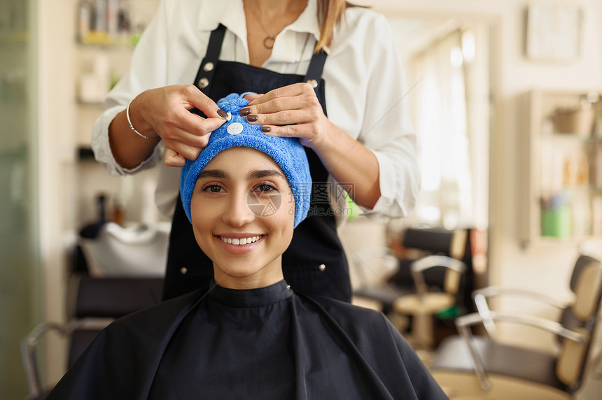 发型师将毛巾贴在妇女和头发前视美沙龙型师和廊客户美容业专服务发型师将毛巾贴在妇女和头发前视图片