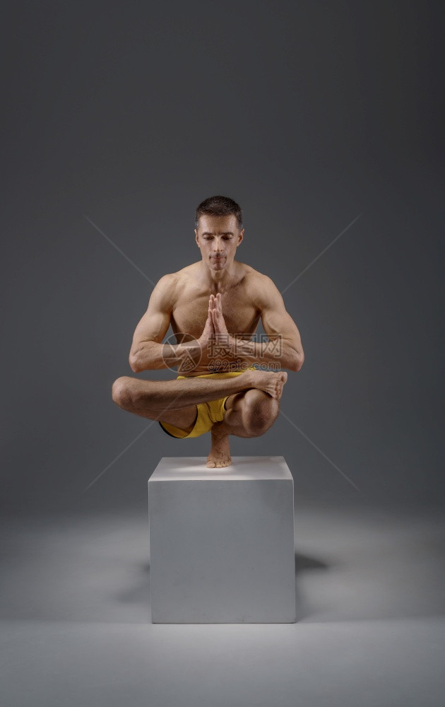 雄瑜伽让巴朗人手举着难摆的姿势在祭坛冥想姿势灰色背景上强壮的人在做瑜伽运动麻培训最高浓度健康的生活方式瑜伽让巴朗人举着难摆的姿势图片