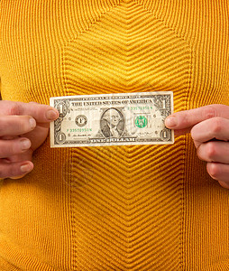 一个穿着黄毛衫的男人拿着一块钱的钞票绿色高清图片素材