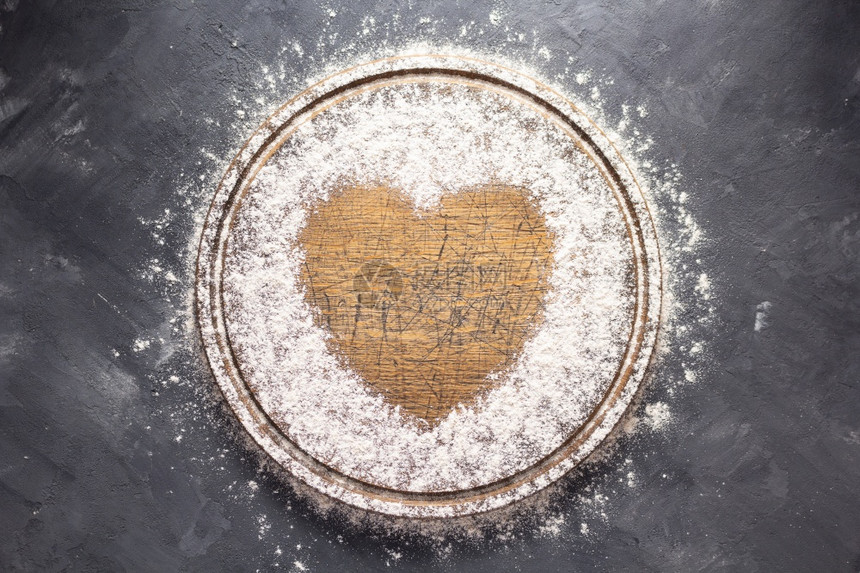 木制比萨或餐桌上自制烘烤的面包切板上粉小麦具有复制空间的石头背景纹理中的食谱概念图片