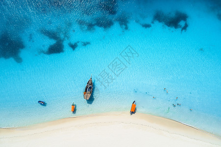 热带海岸的游艇和渔船空中景象夏季日落时有白沙滩背景图片