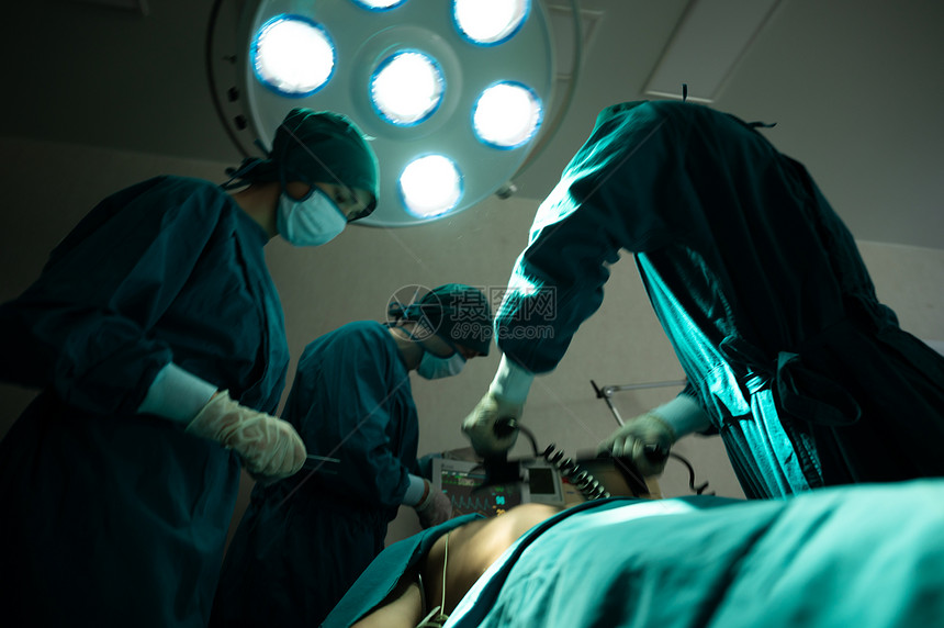 手术室专业外科队紧急外科手术专业智能外科医生站在病人身边救他的同时进行手术图片