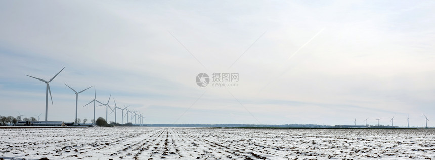 冬季在蓝色天空下用风涡轮机播的falevoland的杜特奇产雪田和农场图片