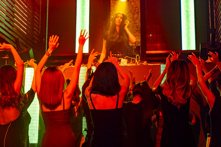 一群人在迪斯科夜俱乐部跳舞音从DJ在舞台上播放新年晚宴和夜生活概念一群人在迪斯科夜俱乐部跳舞音从DJ在舞台上播放背景图片