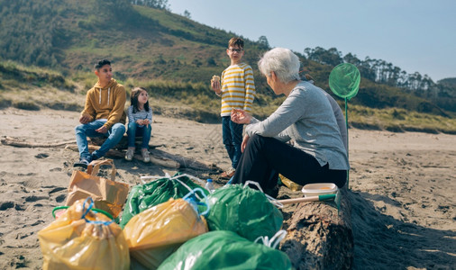 一群在清理海滩后休息和吃饭的志愿者在清理海滩后休息和吃饭的志愿者图片