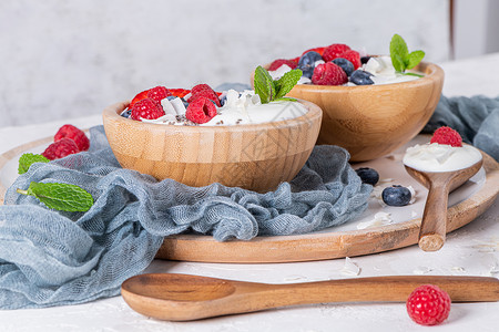 为健康早餐提供酸奶和浆果一碗加草莓蓝和的希腊酸奶勺子高清图片素材