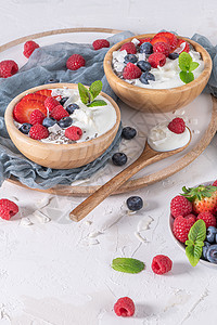 为健康早餐提供酸奶和浆果一碗加草莓蓝和的希腊酸奶坚果高清图片素材