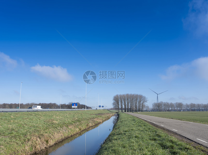A27和A号高速公路附近有草地和树木的乡村公路和田间地上靠近Vianen和Utrecht的蓝天空下地底有蓝天的无带上有草和树木图片