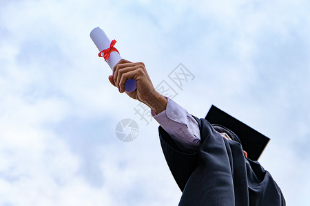 学生祝贺毕业穿着大学毕业礼服的证明书高清图片素材