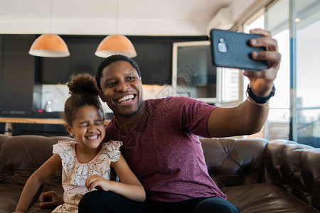 女儿和父亲一起玩手机自拍图片