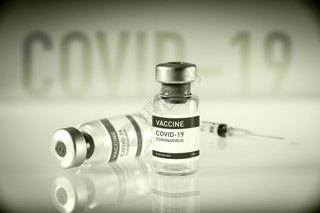 黑白实验室背景的新冠19疫苗瓶和注射器图片