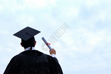 学生祝贺毕业穿着大学毕业礼服的硕士高清图片素材