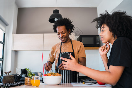 家庭厨房用手机做饭关系烹饪和生活方式概念图片