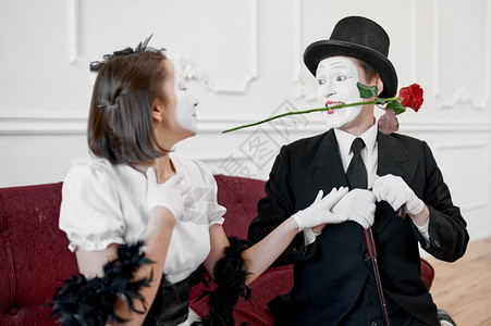 两个模仿艺术家情侣有玫瑰的场景Pantomime剧院喜演员积极的情感幽默表演有趣的面孔模仿和严酷两个模仿艺术家有玫瑰的场景面对高清图片素材